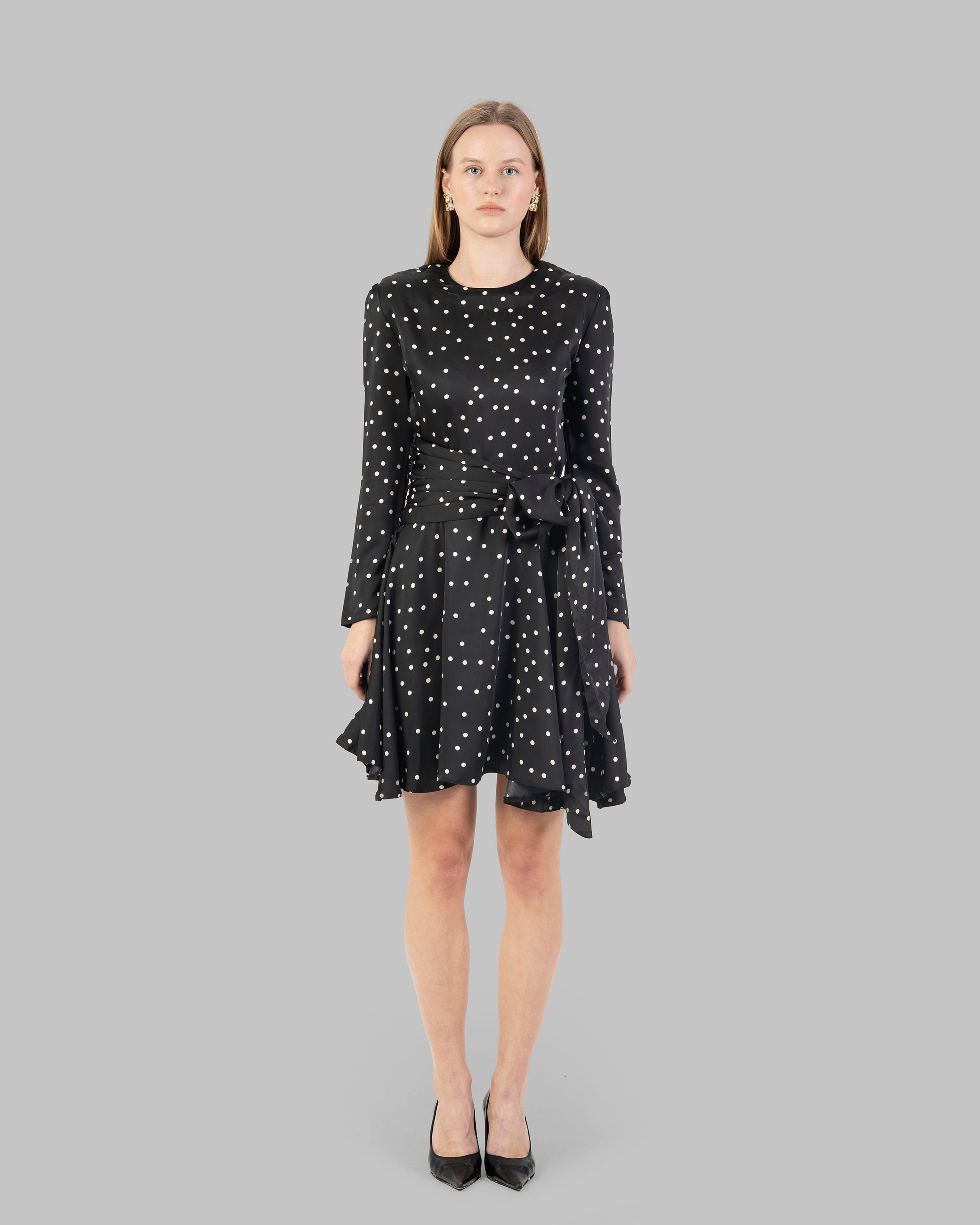 A chic polka dot mini dress with long sleeves and a stylish wrap-around tie waist