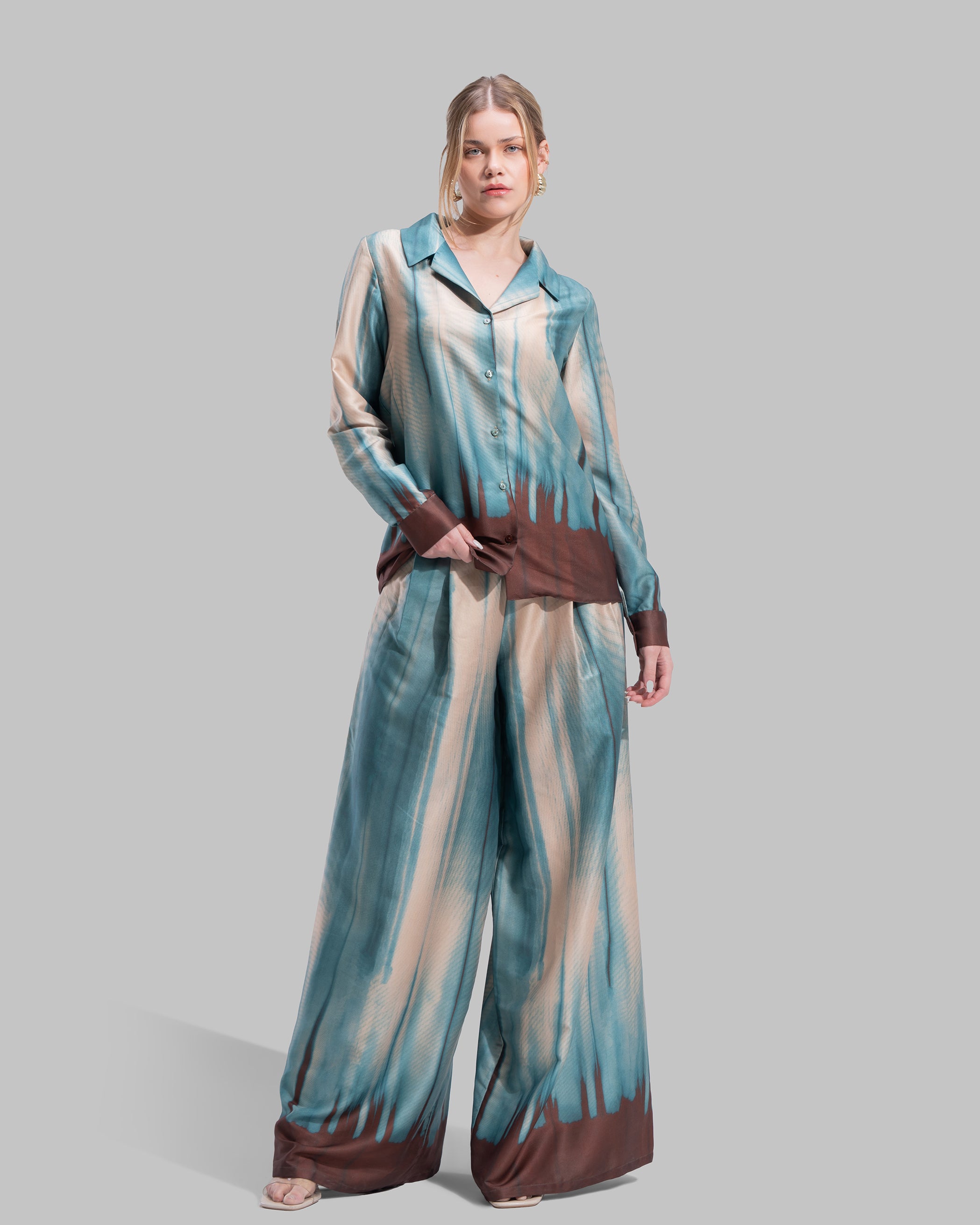 Wide-leg high-waisted trousers in a matching teal and cream abstract gradient pattern.