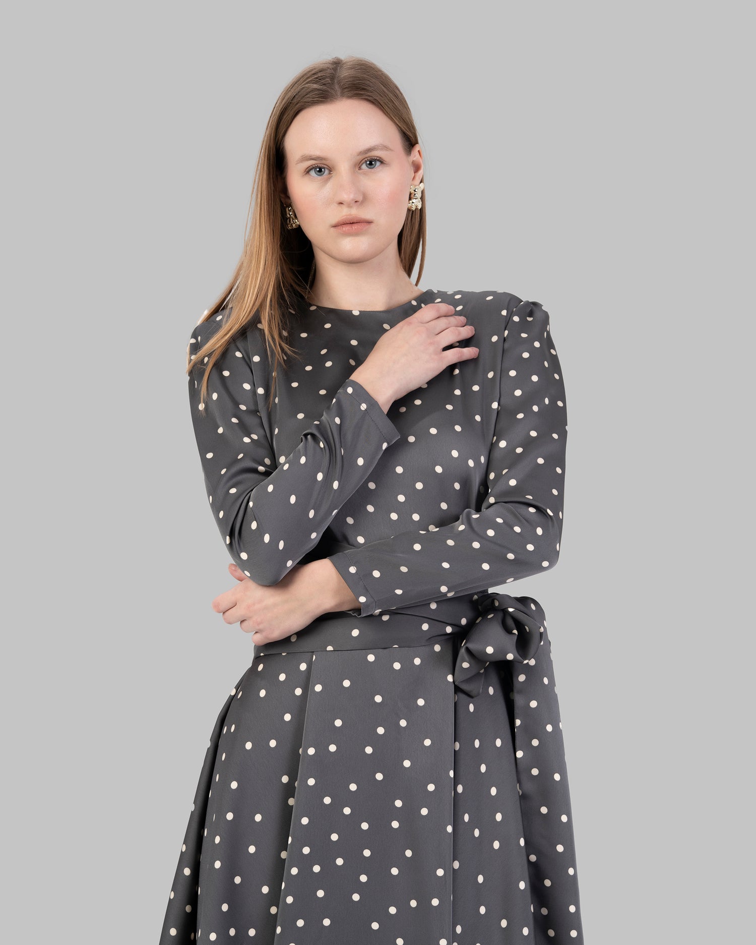 A chic polka dot mini dress with long sleeves and a stylish wrap-around tie waist