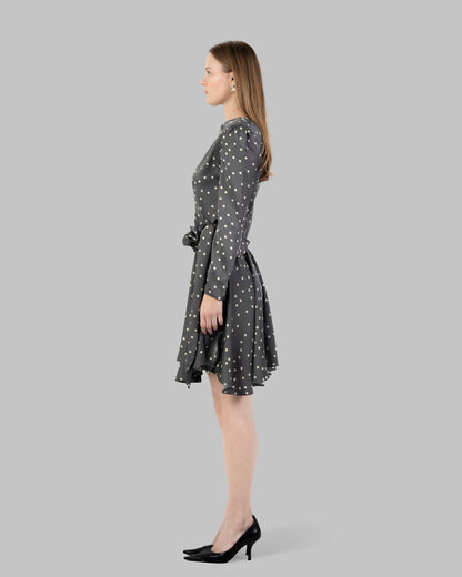 A chic polka dot mini dress with long sleeves and a stylish wrap-around tie waist