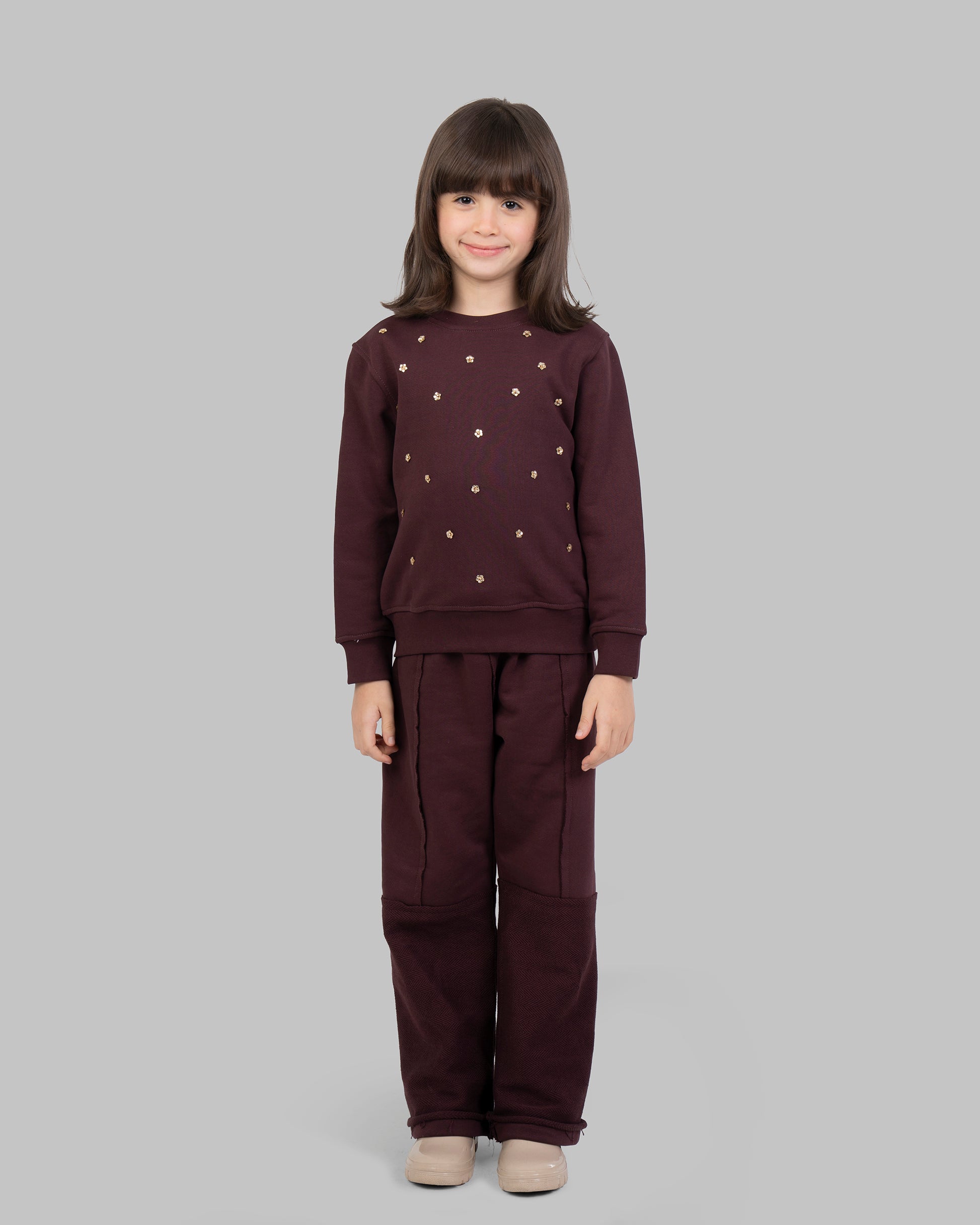 سترة رياضية مزينة بأزهار ذهبية صغيرة متناثرة في الأمام.