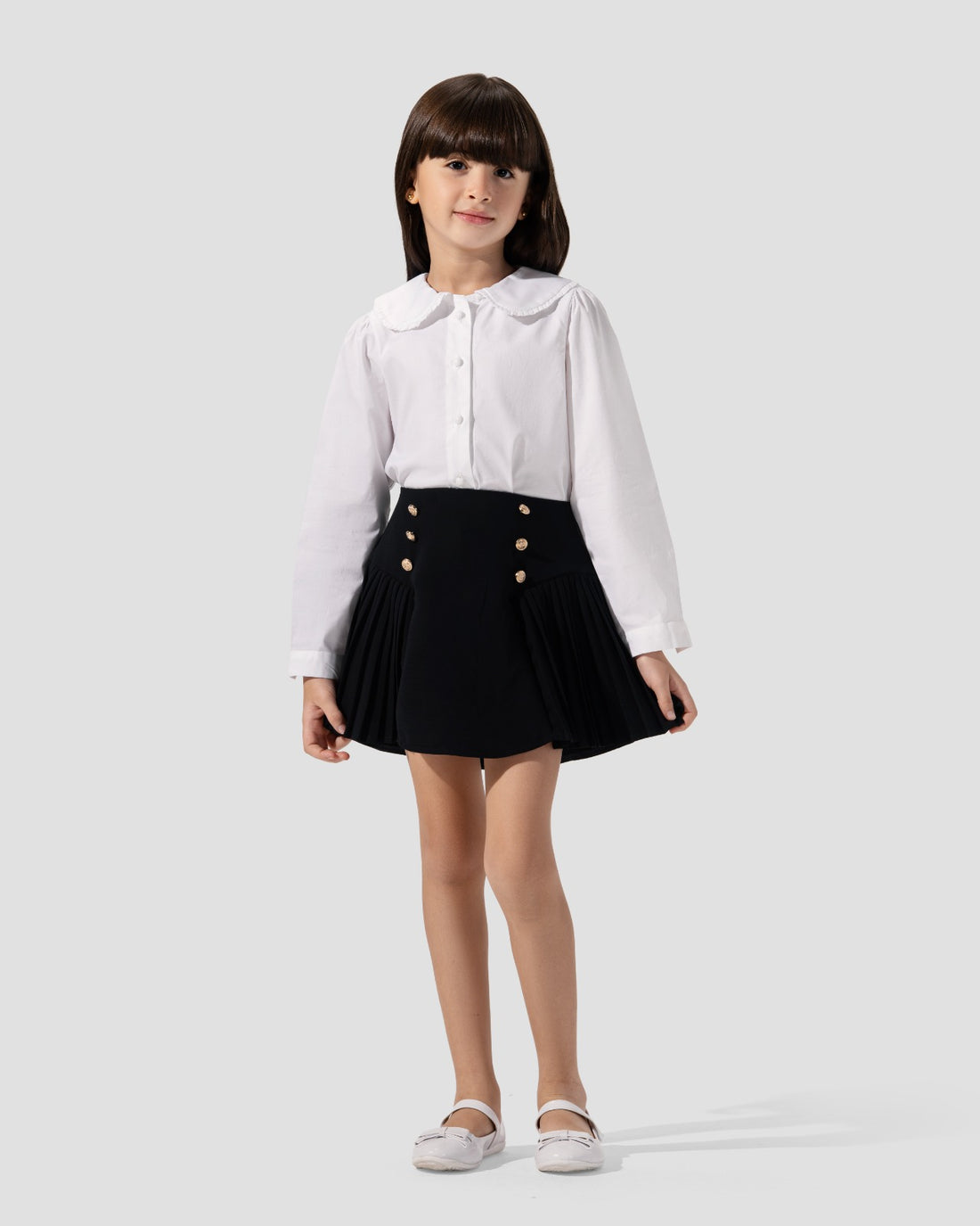 تنورة قصيرة مطوية باللون الأزرق الداكن مع أزرار ذهبية اللون عند الخصر